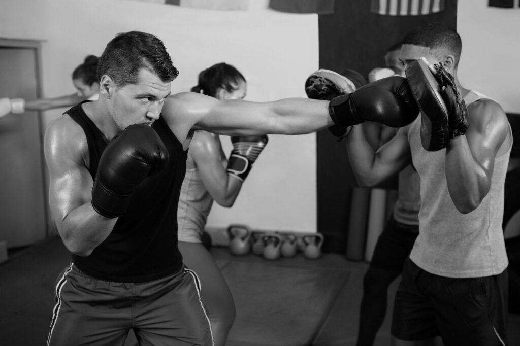 male boxer and instructor practicing with boxing wb
